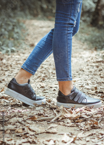 pies de una mujer con tennis caminando sobre hierva y tierra.