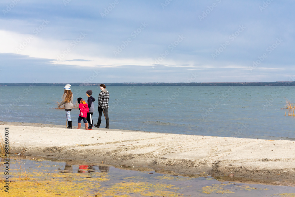 Children walking and adventuring outdoors on beach in fall