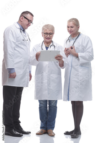 in full growth. group of smiling doctors with a digital tablet.