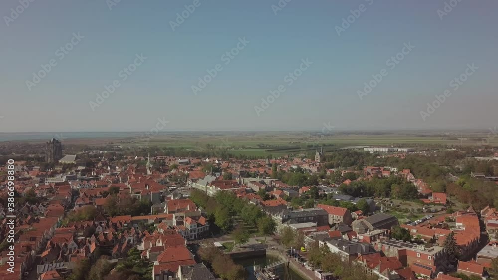 Flight sideways over the town of Zierikzee with red roofs in the south of Netherlands. Sunny cloudless weather with a slightly lower sun. Flight sideways over the town of Zierikzee with red roofs in the south of Netherlands. Sunny cloudless weather with a slightly lower sun.