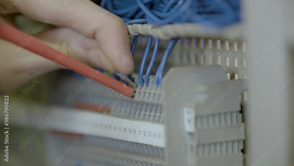 Man fixes cables into electronic device Man fixes cables into electronic device
