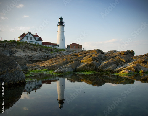 Reflection of a lighthouse on the coast of Maine at sunset during summer