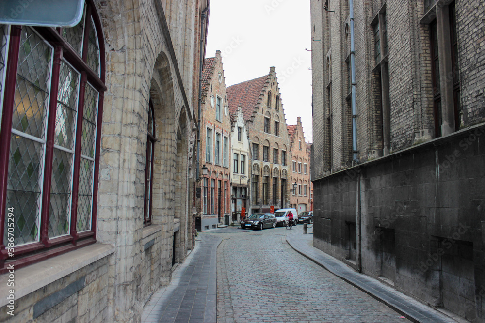 Obraz premium Bruges, Belgium - May 12, 2018: Roofs And Windows Of Old Authentic Brick Houses On Street Vrijdagmarkt
