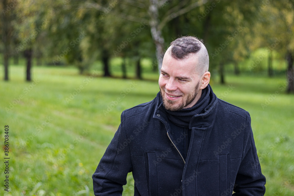 A man walks in a park and smiling A man walks in a park and smiling