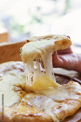 
Georgian cuisine. Food photo. A woman's hand takes a piece with stretching cheese. Appetizing bright photo.