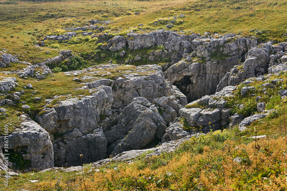 karst hole in the middle of the autumn alpine meadow