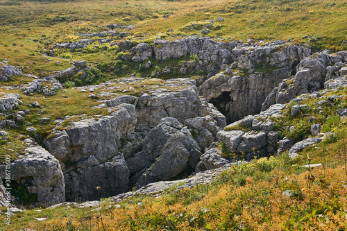 karst hole in the middle of the autumn alpine meadow