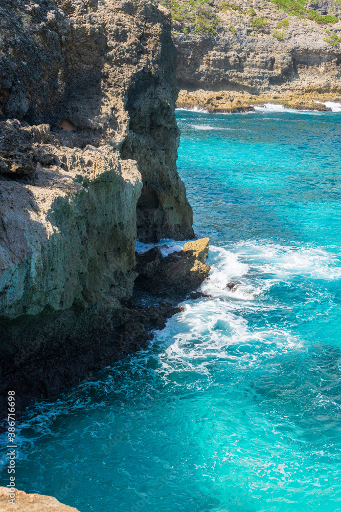 Paysage littoral tropical de falaise avec le ressac de l'océan bleu azur dans un paysage ensoleillé