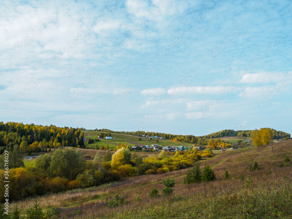 Beautiful landscape view of hillsides and village at the fall time in vibrant colours.