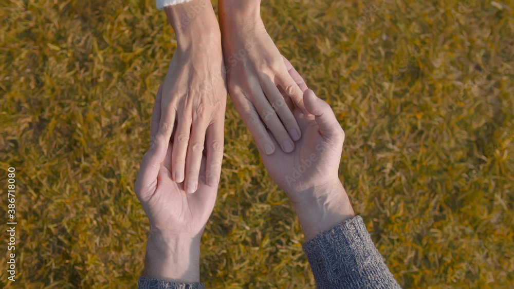 Top view of senior couple holding hands relaxing outdoors Top view of senior couple holding hands relaxing outdoors