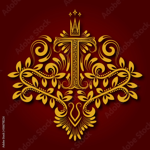 Letter T heraldic monogram in coats of arms form. Vintage golden logo with shadow on maroon background. Letter T is surrounded by floral elements of design.