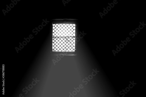 Cinematic dark mood shot of windows with some sunlight coming through in the dark room.