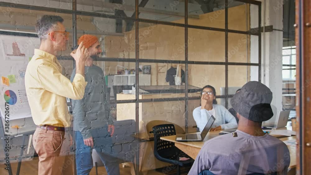 Multiethnic business team discussing marketing strategy at office, tracking shot Multiethnic business team discussing marketing strategy at office, tracking shot
