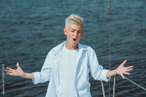 handsome Caucasian boy singing on the yacht  © k8most