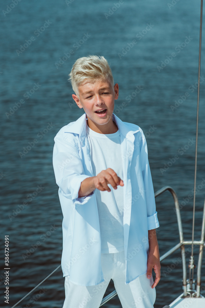 Fototapeta premium handsome Caucasian boy singing on the yacht 