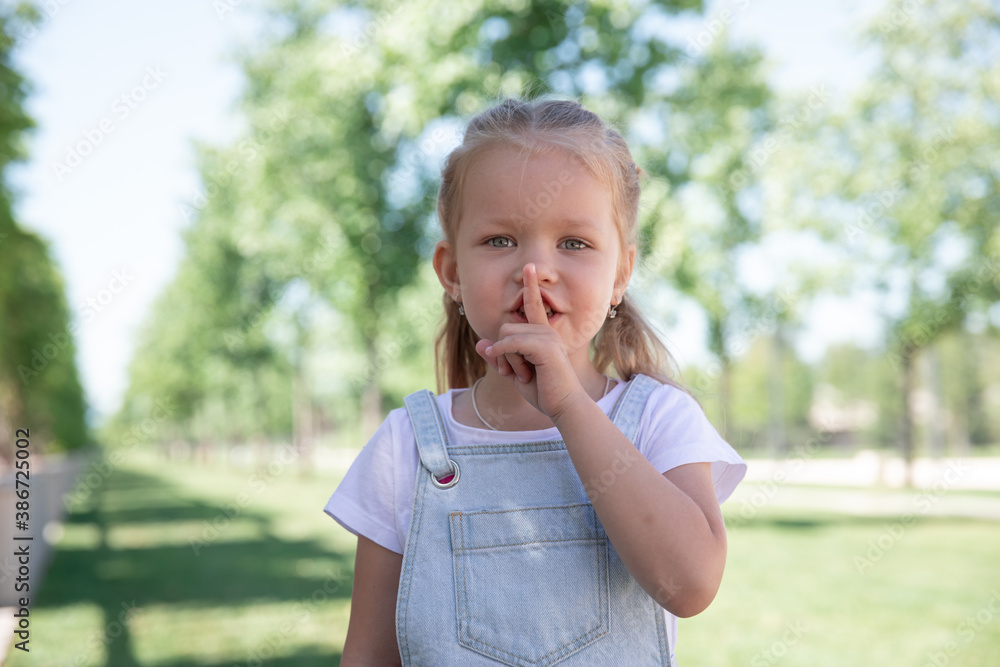 Closeup portrait of little girl holding her finger to her lips. Closeup portrait of little girl holding her finger to her lips.