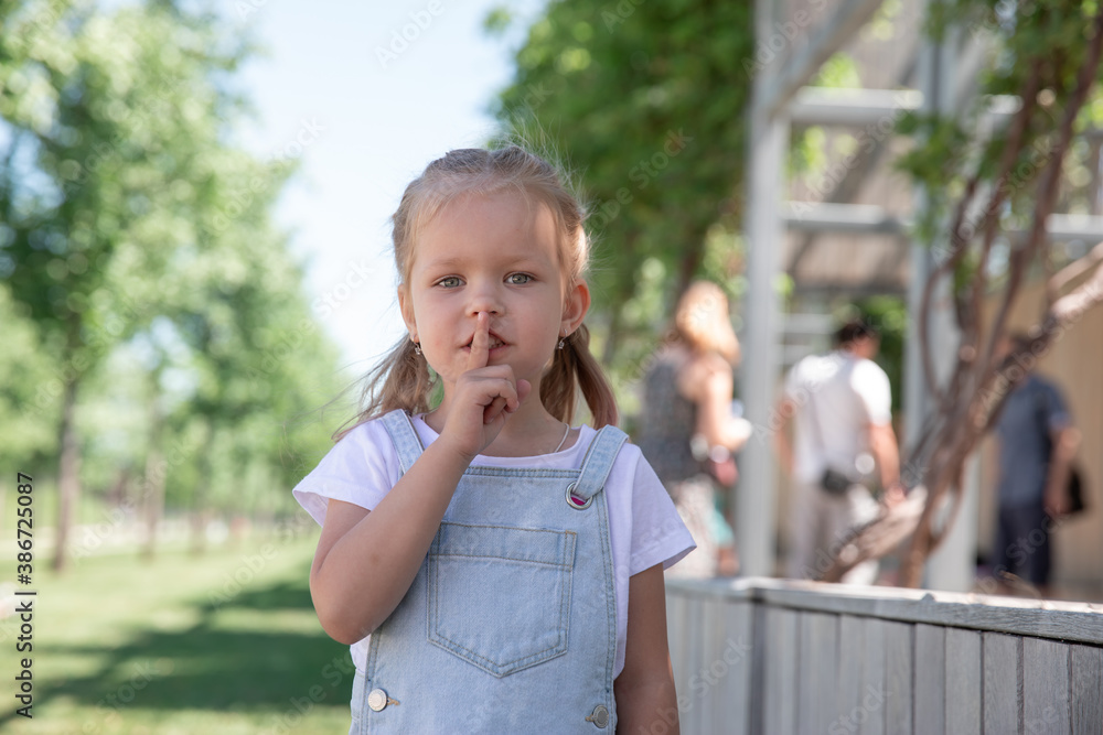 Closeup portrait of little girl holding her finger to her lips. Closeup portrait of little girl holding her finger to her lips.