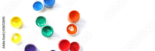 Banner. Opened cans of paint. View from above. colorful finger paints over white background
