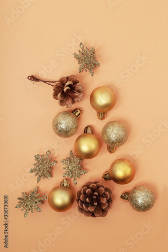 adornos de navidad dorados componiendo un pino navideño sobre un fondo alegre 