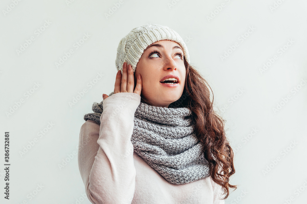 Laughing girl wearing warm clothes hat and scarf isolated on white background