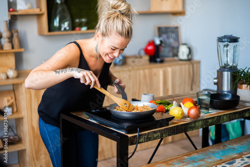 Photography Plano corto de hermosa mujer feliz cocinando plato típico oriental
