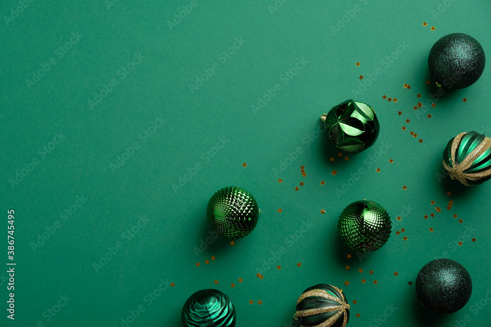 Green Christmas background with green baubles and confetti. Greeting card template, Xmas banner mockup. Flat lay, top view.