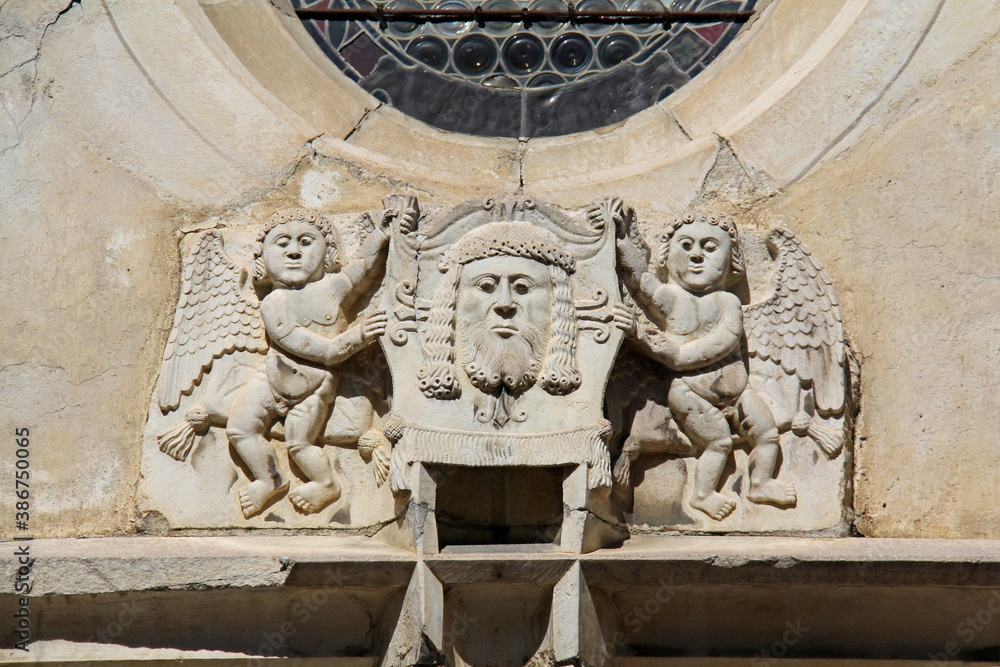 due Angeli reggono il telo della Veronica; scultura sopra il portale gotico della Chiesa dell'Ospedale (Spitalkirche) a Laces (Alto Adige)