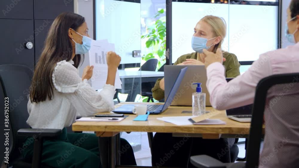 Three Young Business Colleagues In Face Masks Having a Discussion Three Young Business Colleagues In Face Masks Having a Discussion