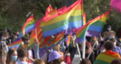 Blured unfocused crowd people with rainbow LGBT flags