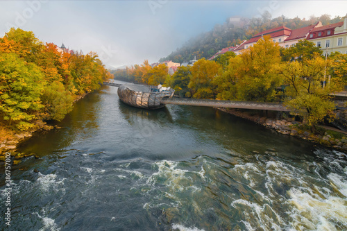 Graz, Austria- October 18, 2019: Mur river in autumn, with Murinsel bridge and old buildings in the city center of Graz, Styria region, Austria.
