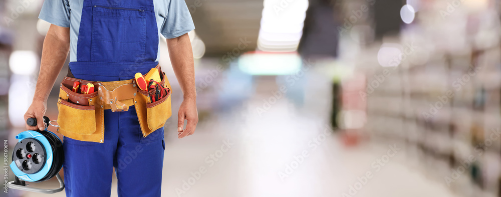 Closeup view of electrician with tools at store, space for text. Banner design - obrazy, fototapety, plakaty 