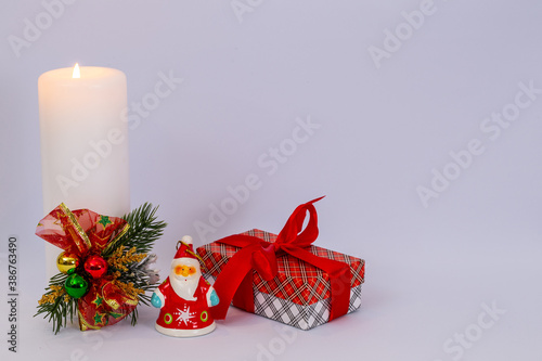 Christmas holidays composition on white background with Christmas decoration, white candle and gifts. Copy space for text.