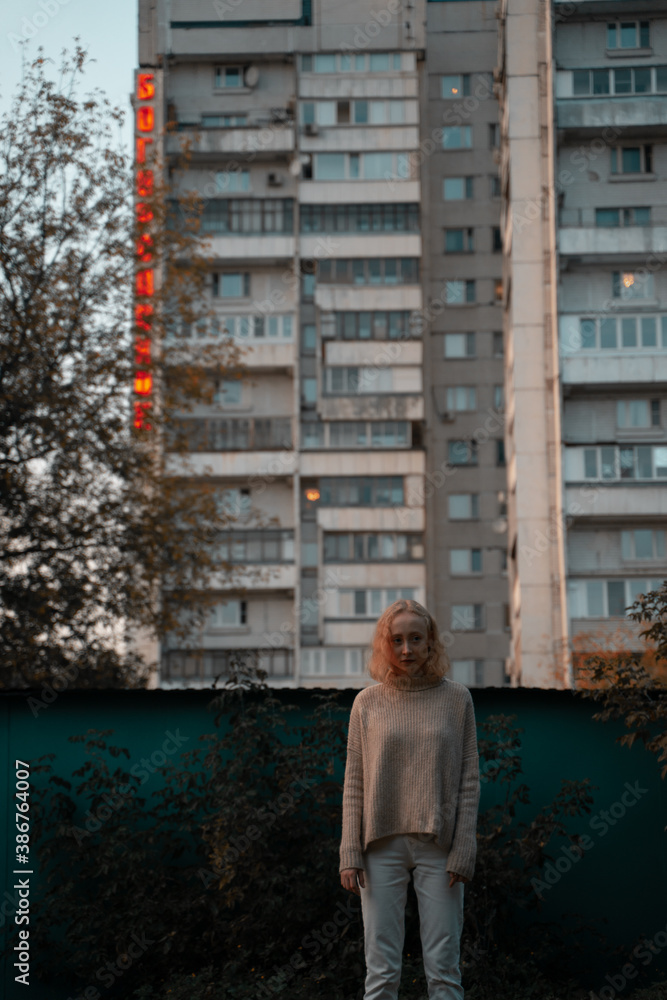 Young girl on the background of a residential building Young girl on the background of a residential building