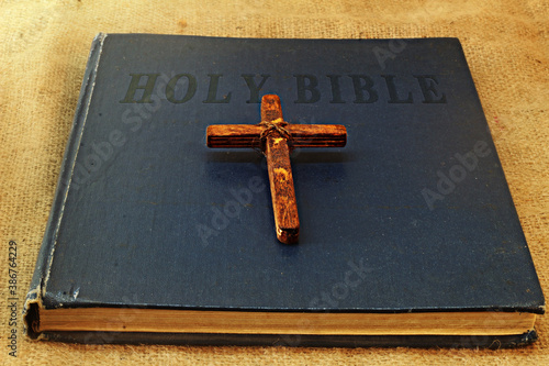 Wood Symbol of Christianity Christian Cross and Vintage Book Holy Bible in English. Concept: Christian religion and traditions photo