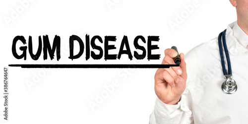 Doctor writes the word - GUM DISEASE. Image of a hand holding a marker isolated on a white background.