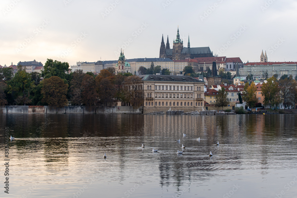 Vltava river and Prague Castle St. Vitus Cathedral and Charles Bridge in the center of Prague at sunset. there are reflections on the river surface and the sky is illuminated by the sun