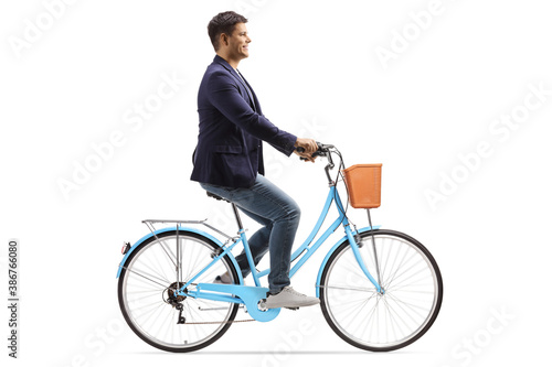 Profile shot of a young man riding a blue bicycle