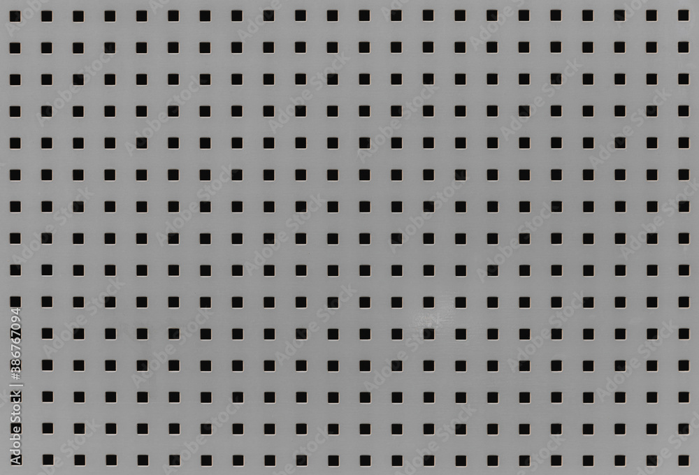 Background with many small square holes. Grey metal sheet with through square holes, textured iron. Metal grill with holes. Close-up view Background with many small square holes. Grey metal sheet with through square holes, textured iron. Metal grill with holes. Close-up view
