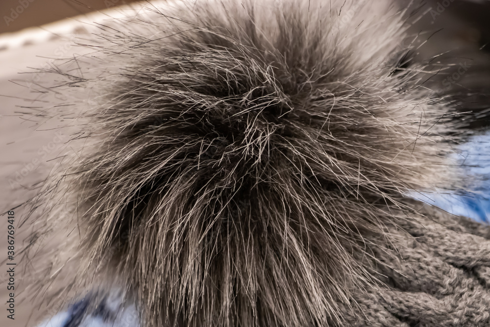 Fluffy pompon on a knitted hat close-up. Fluffy pompon on a knitted hat close-up.