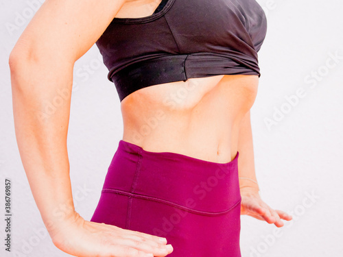 Close-up of sporty young woman doing hypopressive exercise.