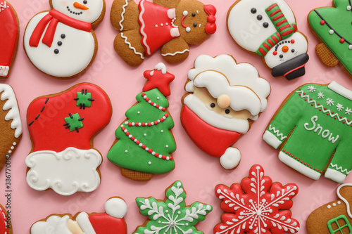Different Christmas gingerbread cookies on pink background, flat lay