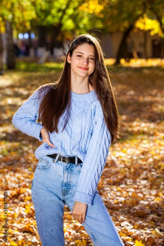 Portrait of a young girl in blue sweater  autumn park outdoor