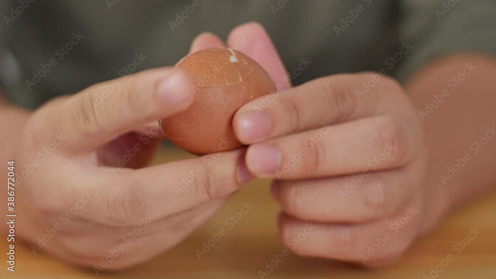 Hands peel eggshells from boiled egg. Opening hard boiled egg, protein source Hands peel eggshells from boiled egg. Opening hard boiled egg, protein source