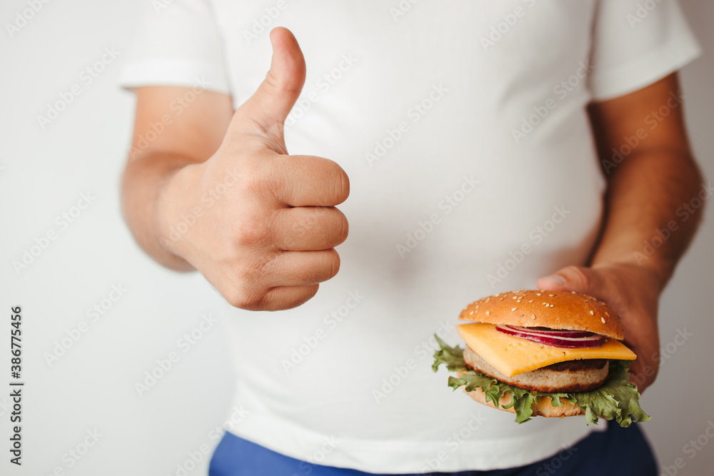 Overweight man with burger and thumb up Overweight man with burger and thumb up