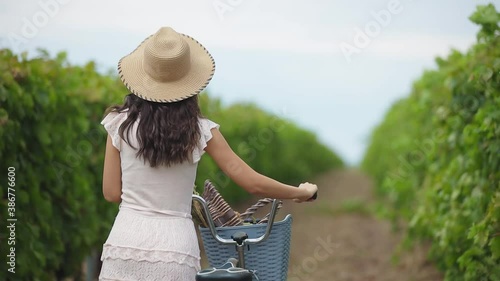 caucasian woman with hat and bicycle tour the vineyard