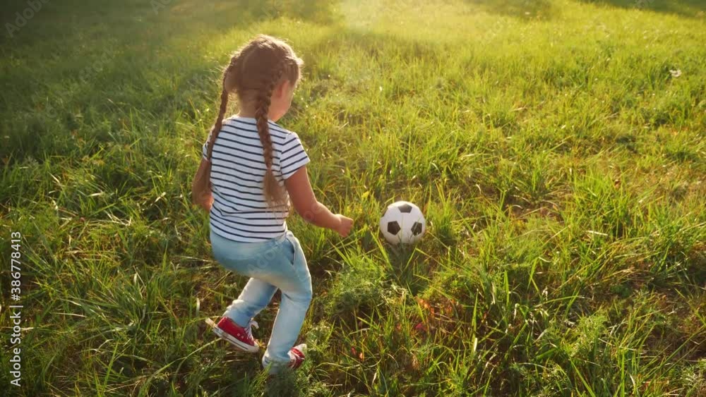little girl play soccer in the park with a ball. kid dream concept. kid play ball on green grass in the park. child playing soccer. people in fun the park concept little girl play soccer in the park with a ball. kid dream concept. kid play ball on green grass in the park. child playing soccer. people in fun the park concept