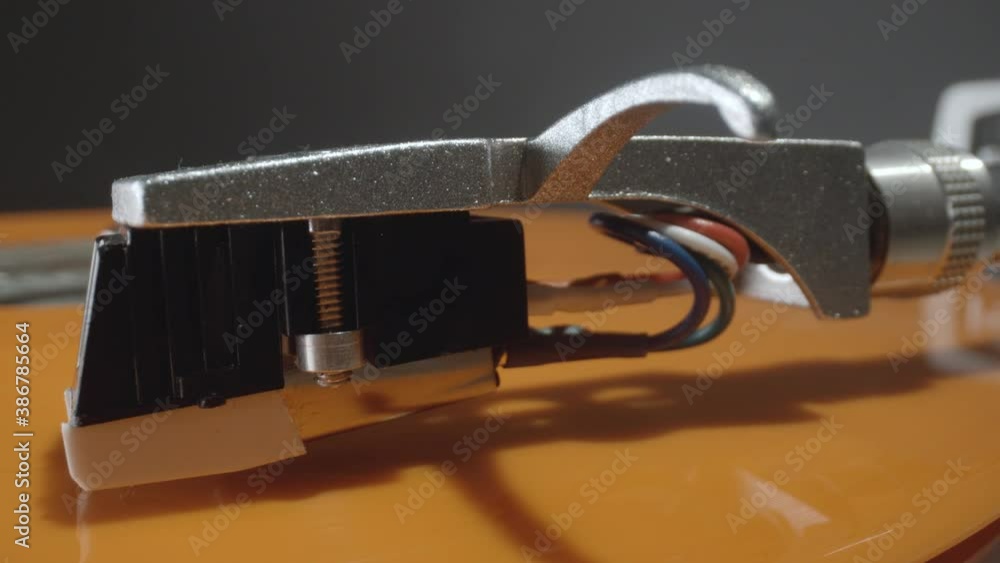 Stylus on record player with orange vinyl Stylus on record player with orange vinyl