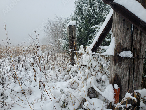 snow covered wooden barbed wire fence 