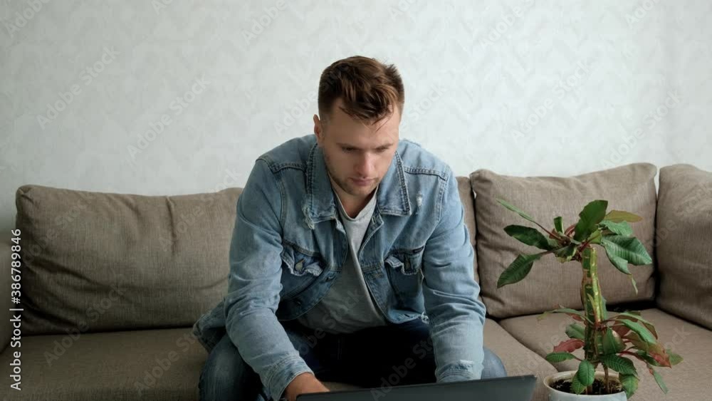 A handsome man uses a laptop. Work at home. Freelance. Distant work. A handsome man uses a laptop. Work at home. Freelance. Distant work.
