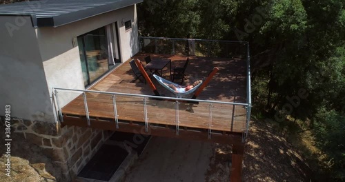 Drone shot towards girl laying in a hammock relaxing on a resorts terrace, in Douro valley, sunny day. in Porto, Portugal - dolly, aerial view photo